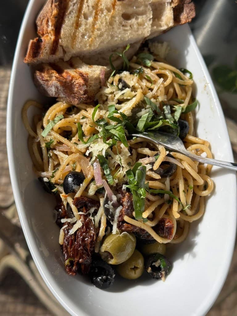 Mediterranean pasta with olives, sun-dried tomatoes, basil, and grilled bread